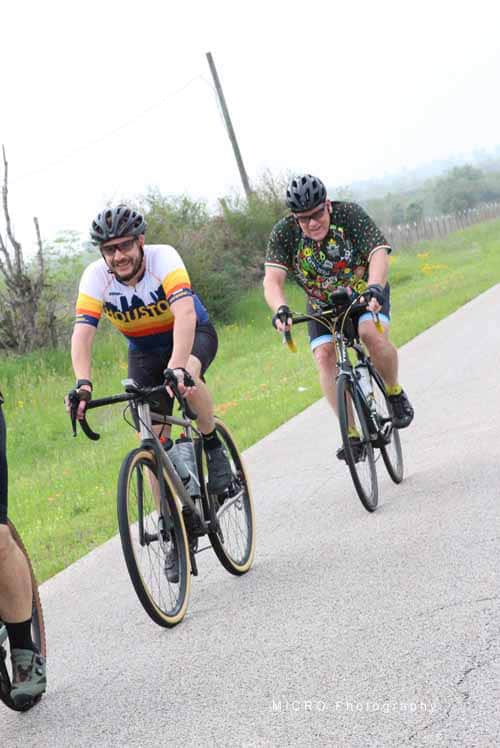 Brightly dressed cyclists enjoying the Bluebonnet Express bike ride on a scenic rural trail.