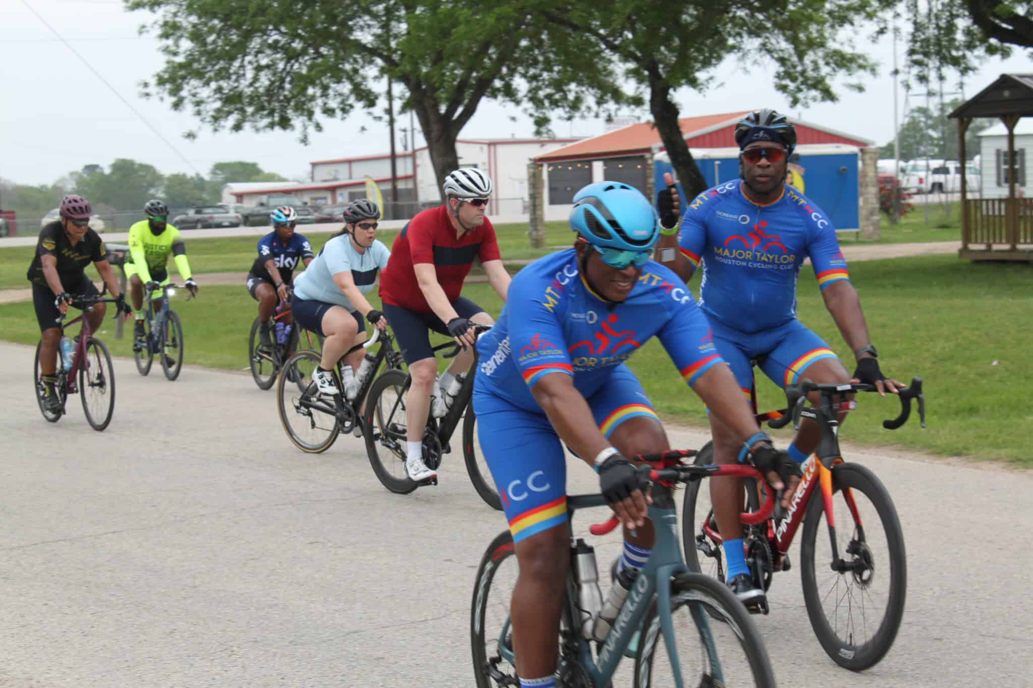 Vibrant cyclists participating in a Bluebonnet Express charity bike race event outdoors.