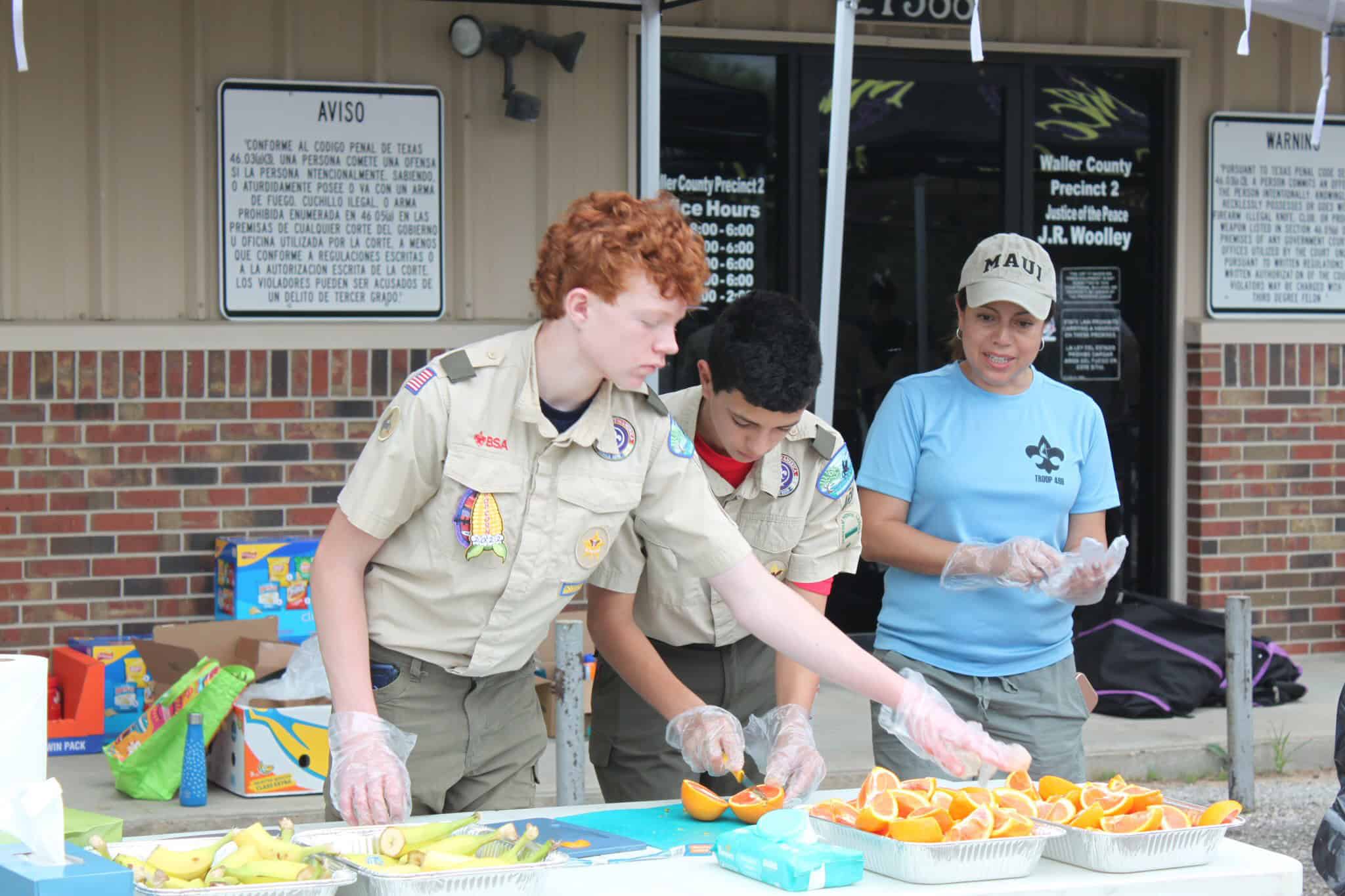 Fresh orange slices served by scouts at a community event for healthy snacks.