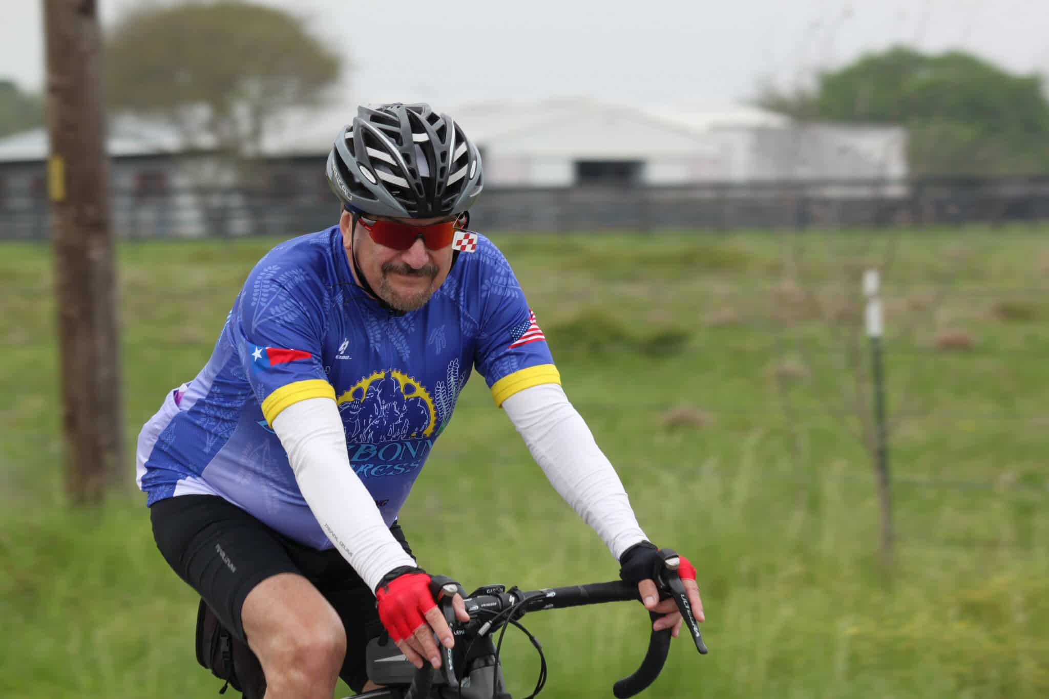 Vibrant Bluebonnet Express cycling jersey worn by cyclist on a scenic outdoor ride.