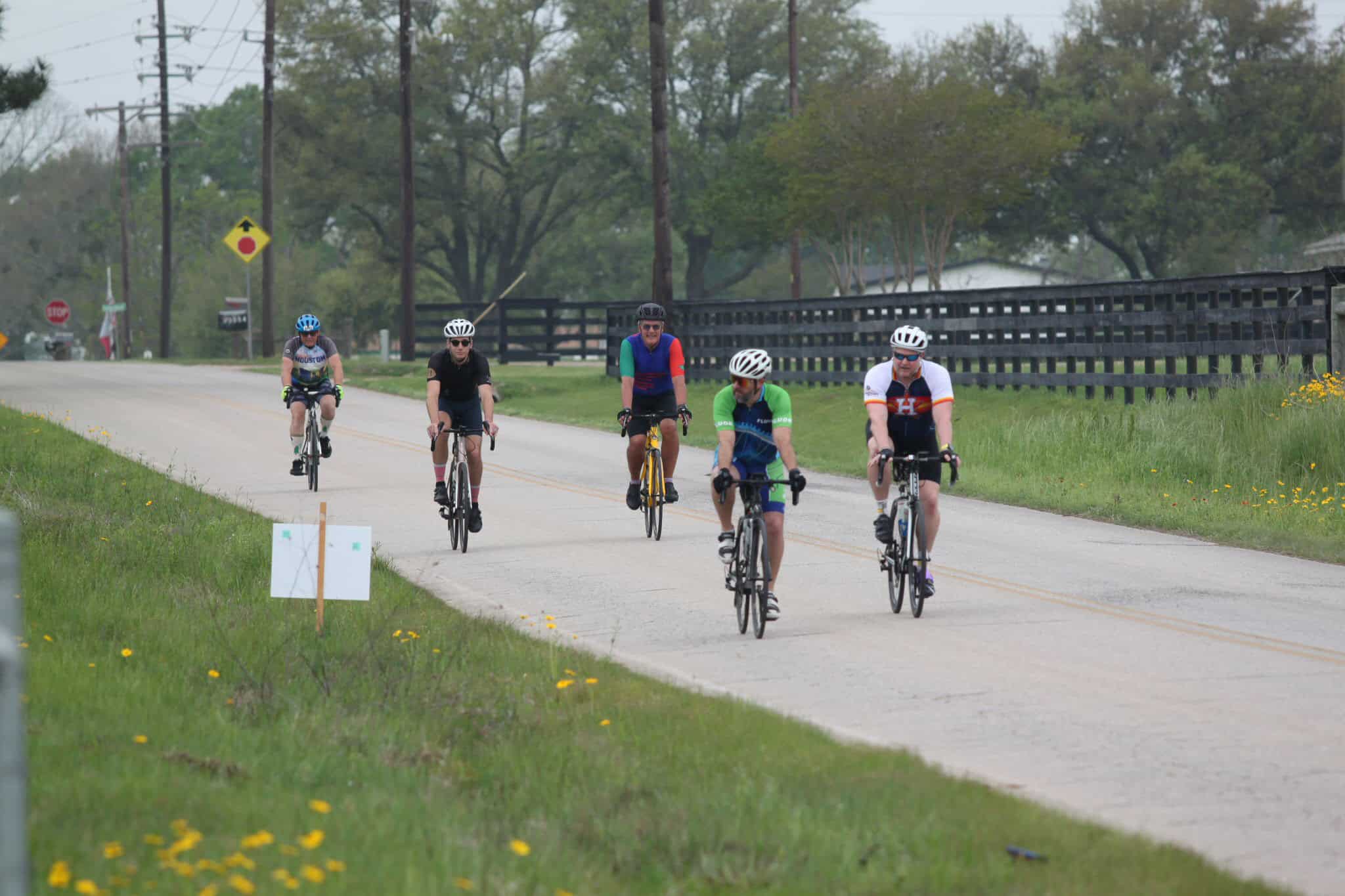 Bicycle riders on a rural street enjoying biking outdoors.