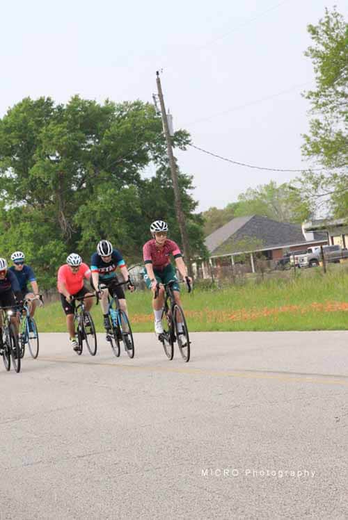 Vibrant cyclists riding together during Bluebonnet Express event on a sunny day.