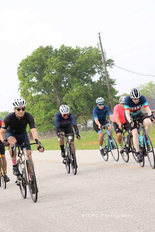 1. Group of cyclists riding on a rural road during daytime for Bluebonnet Express event.