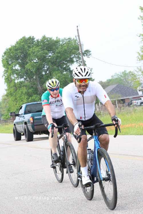 Brightly dressed cyclists riding on the road during Bluebonnet Express event in Texas.