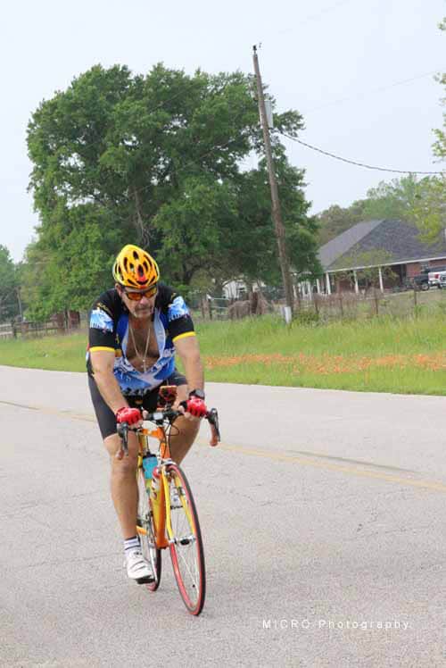 Bright yellow cyclist helmet and colorful bike during Bluebonnet Express ride.
