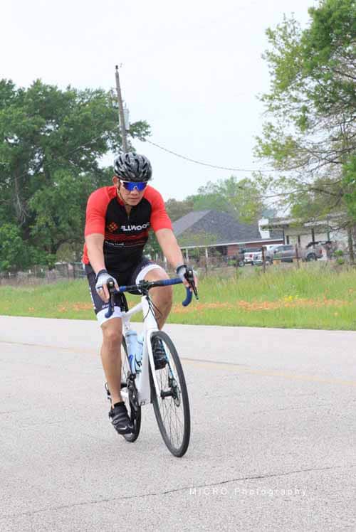 Bright cyclist riding a bike in a suburban neighborhood for Bluebonnet Express event.