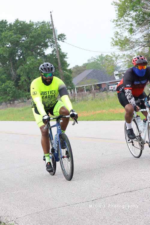 Elegant cyclist riding on a suburban road wearing high visibility gear and helmet.