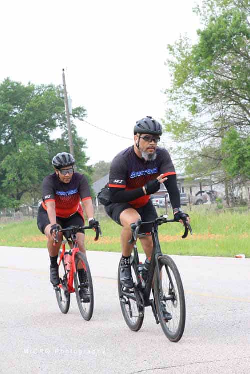 High-performance cyclists riding on a rural road for fitness and recreation.
