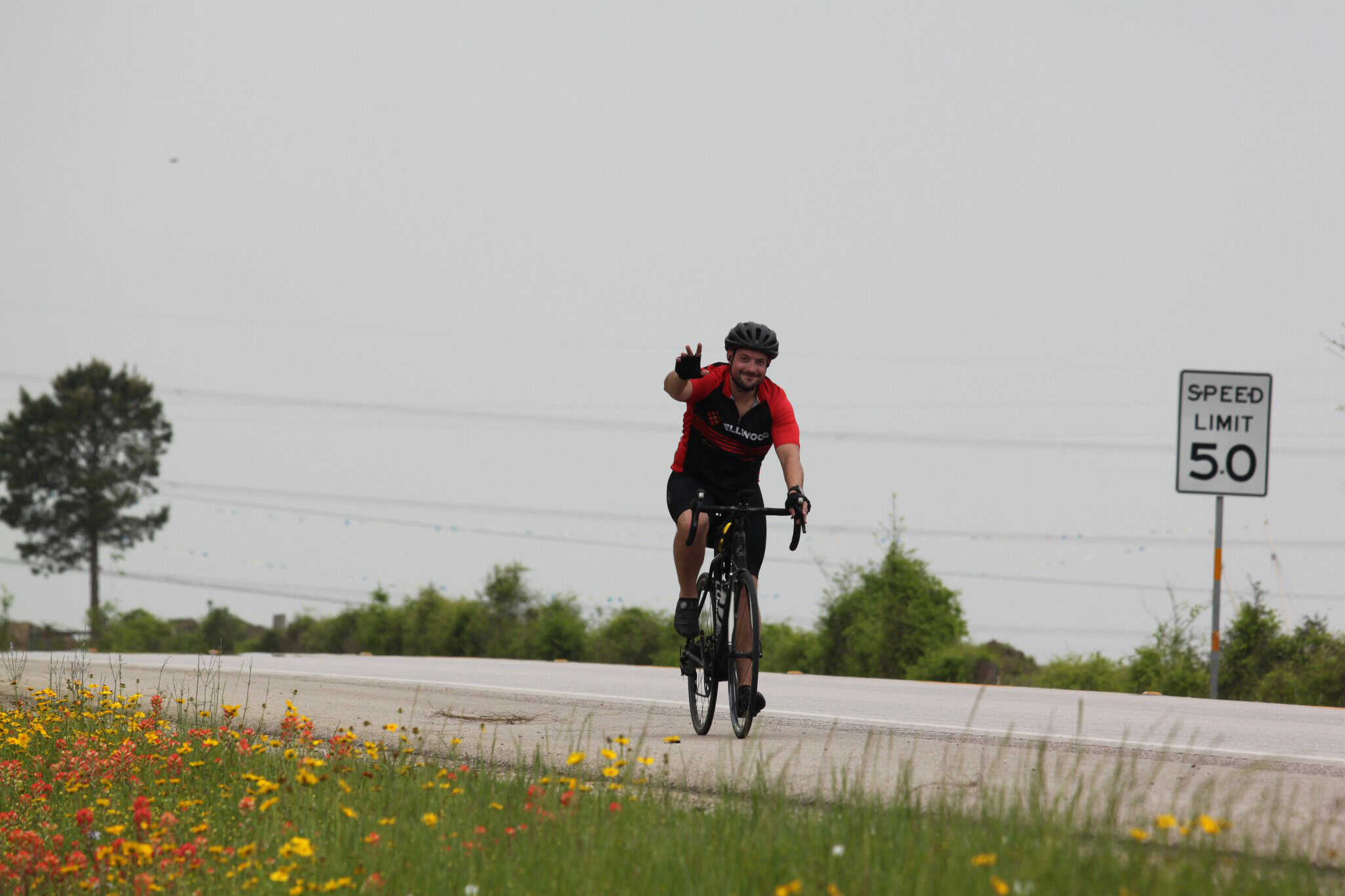 Bright cyclist riding on rural road, promoting Bluebonnet Express bike services near Texas.