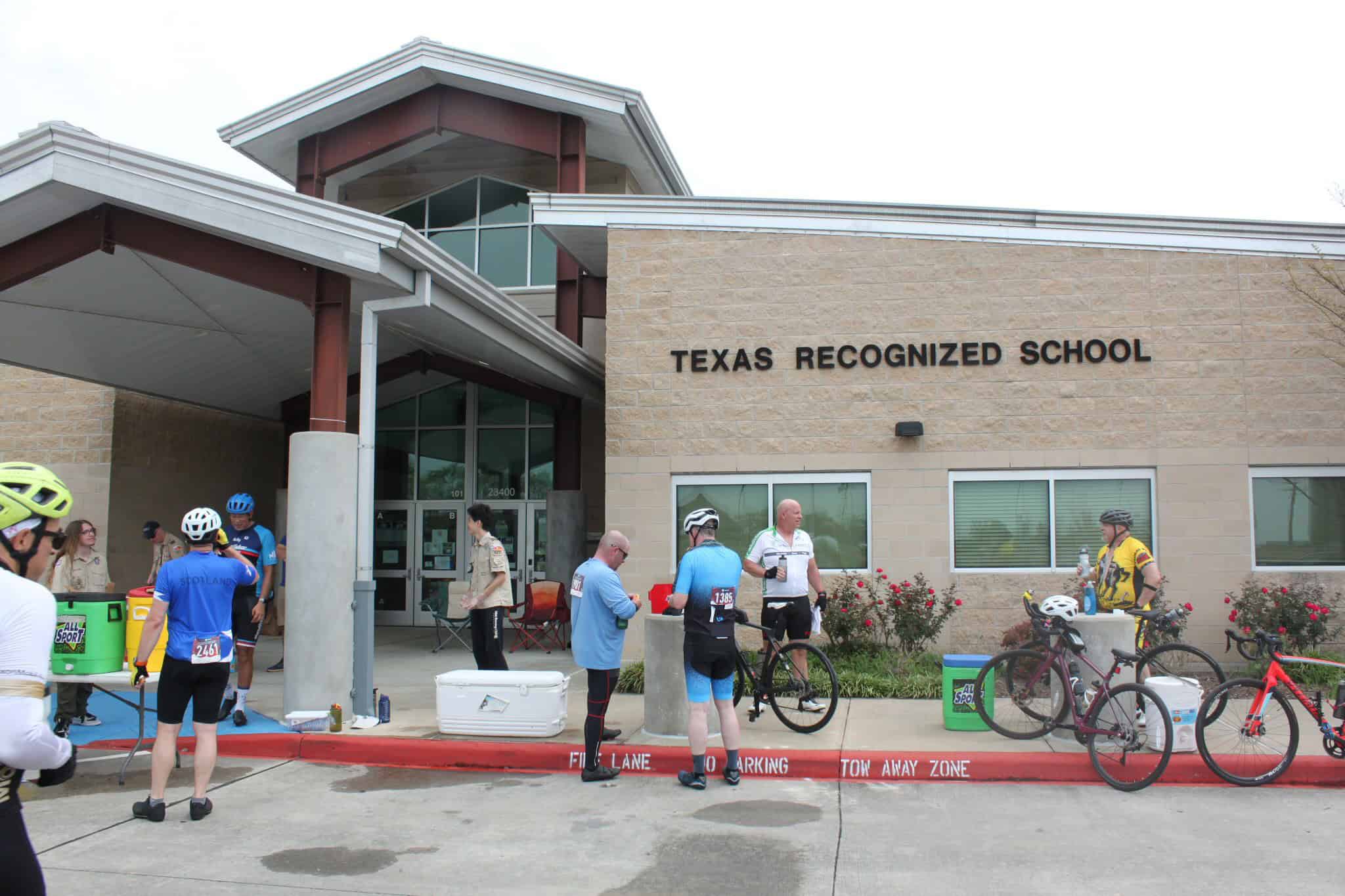 Bright blue cyclists' jerseys at Texas Recognized School during Bluebonnet Express bike event.