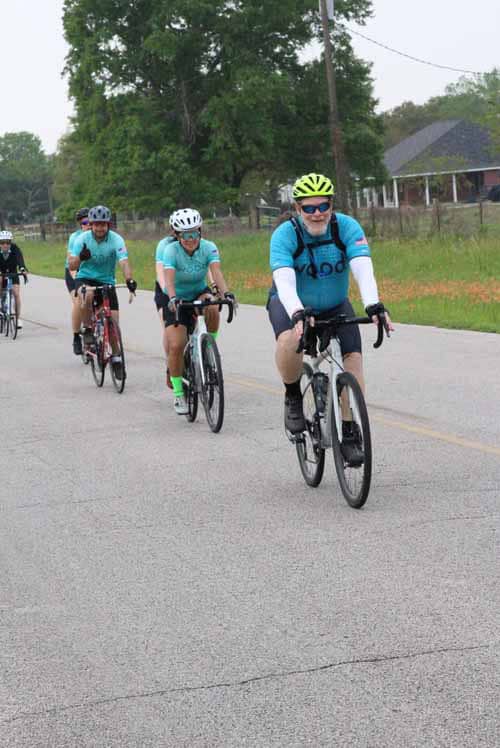 Bright blue bikes and helmets, group cycling event on a rural road, promoting active lifestyles and outdoor adventures.