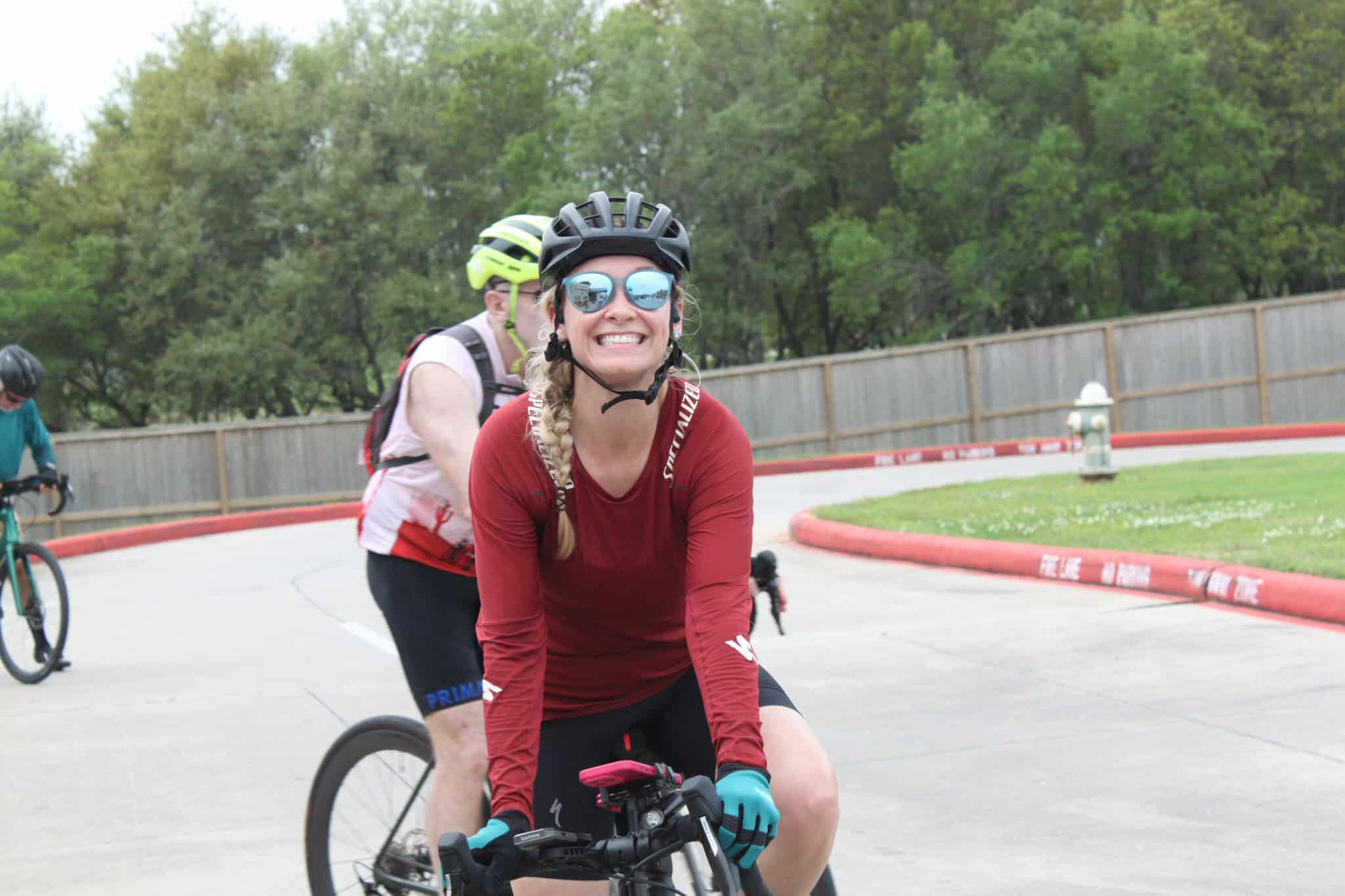 Bright smiling woman riding a bike during Bluebonnet Express cycling event outdoors.