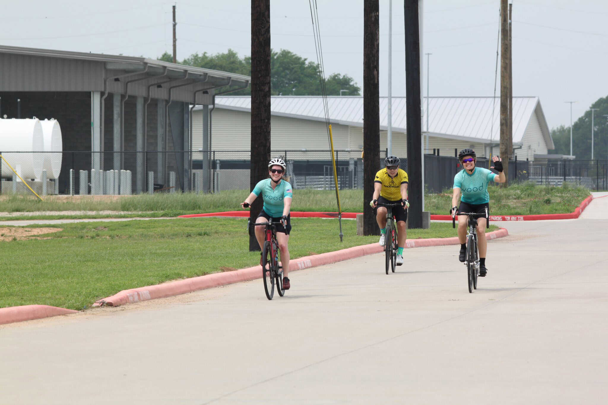 Cyclists riding on a paved bike path in Texas, with "Bluebonnet Express" branding and scenic surroundings.