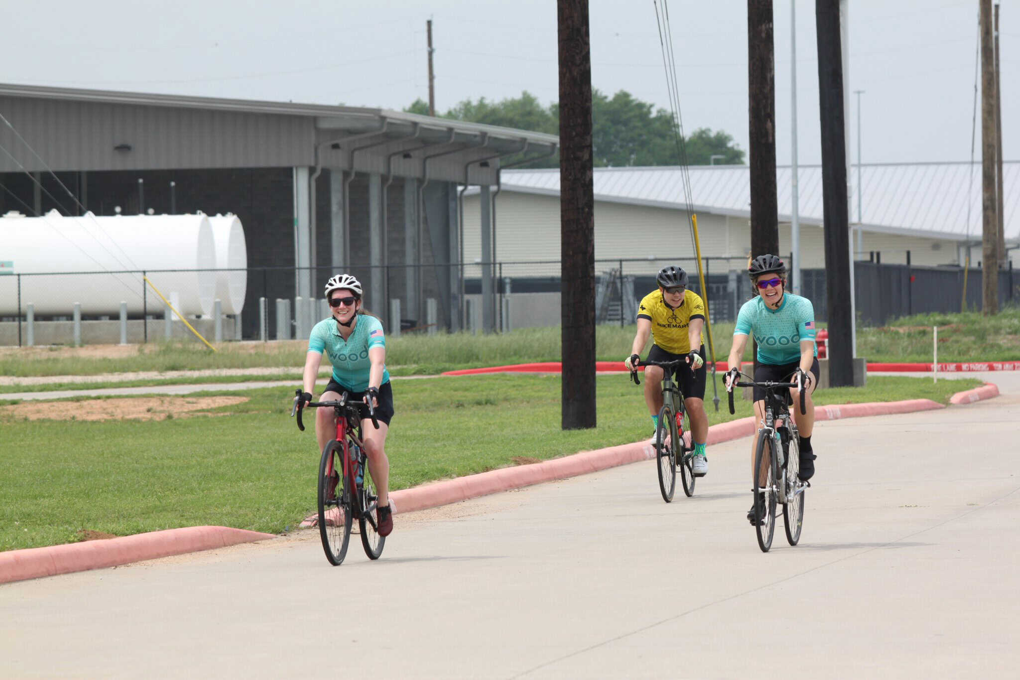 Brightly colored cyclists riding on a paved bike path during daytime for Bluebonnet Express event.