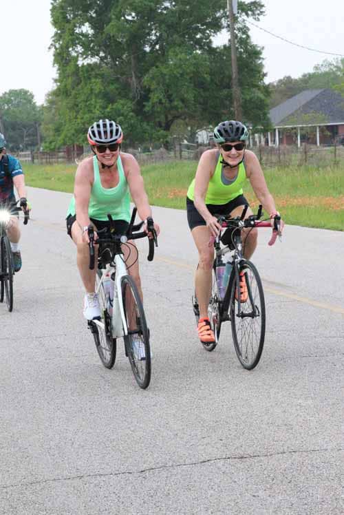 Women cycling on road in daylight, Bluebonnet Express, Texas bike ride, outdoor fitness, cycling event, healthy lifestyle.