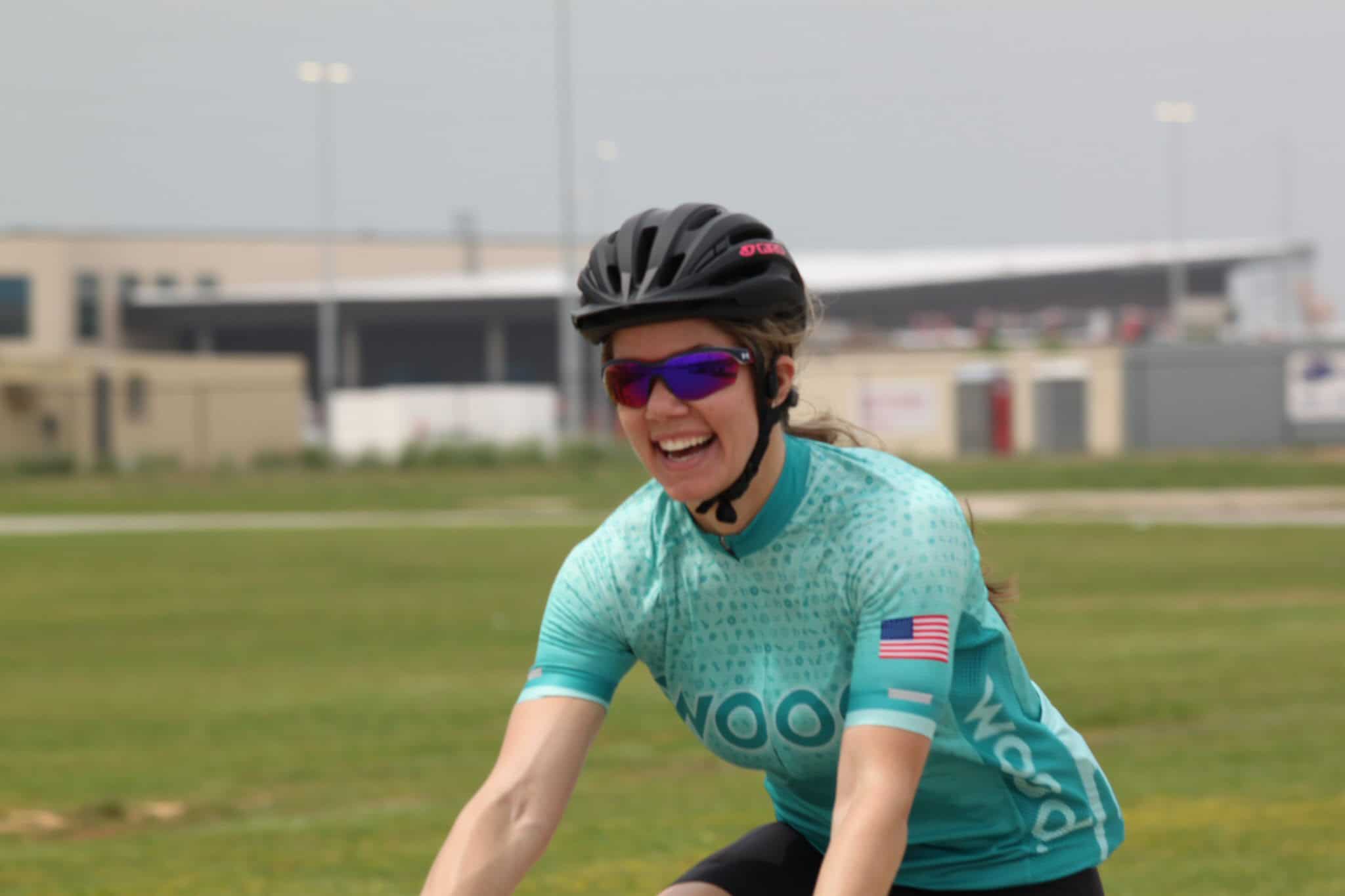 Smiling female cyclist enjoying a ride with Bluebonnet Express bike shuttle service in Texas.