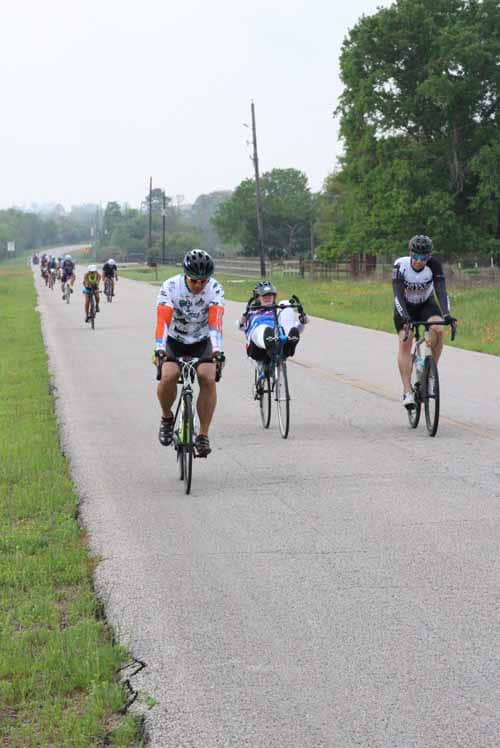 Cyclists riding on a scenic Texas road during Bluebonnet Express event, enjoying outdoor biking adventure.