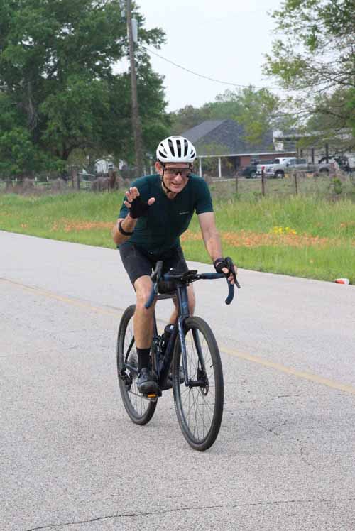 Bright cyclist on Bluebonnet Express bike route, enjoying scenic Texas countryside ride.