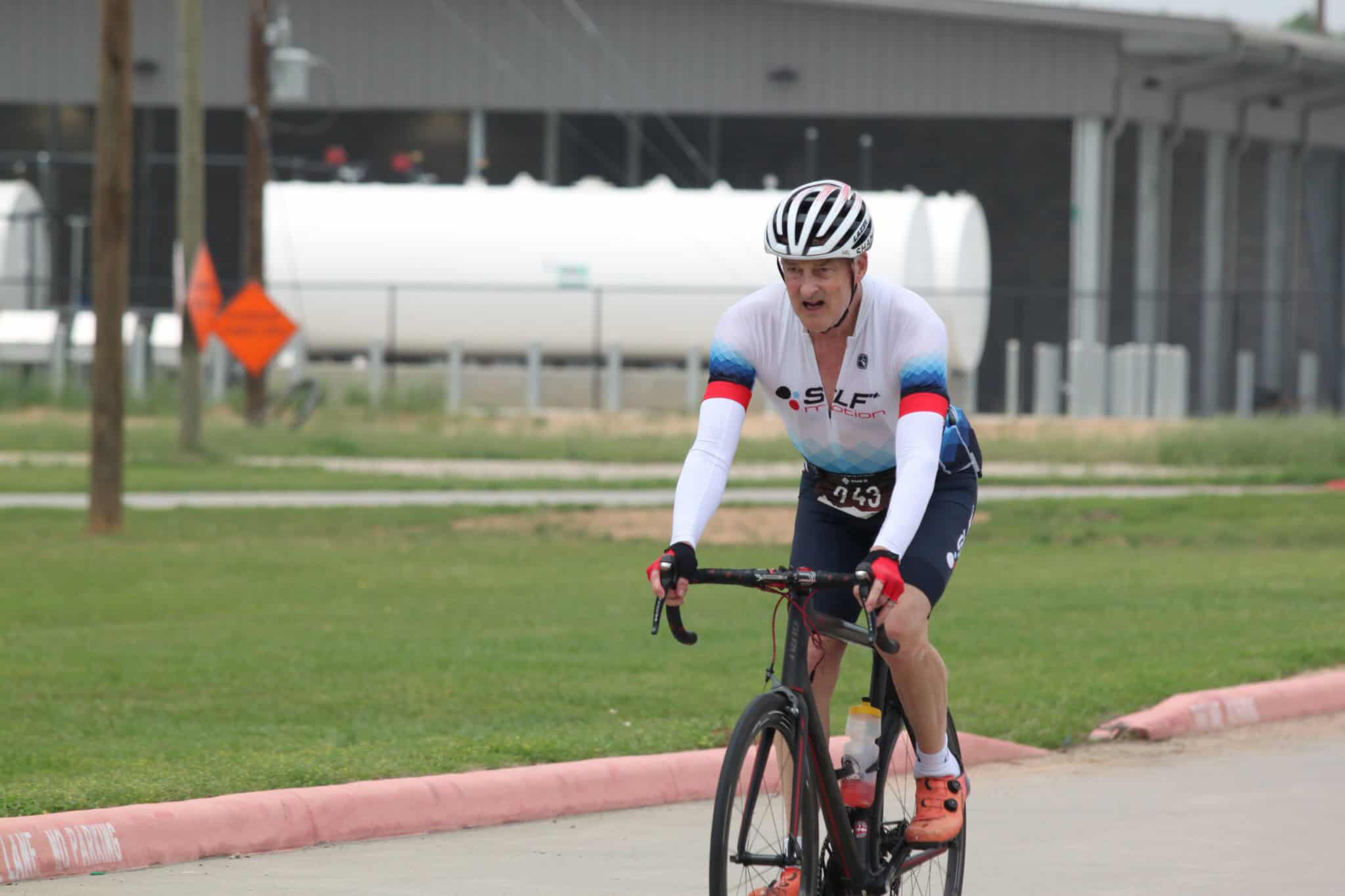High-performance cyclist riding on a race course during a competitive event.