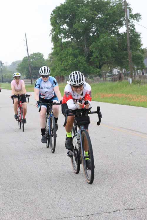 Brightening the ride: group of cyclists in colorful jerseys enjoying Bluebonnet Express scenic ride on rural road.