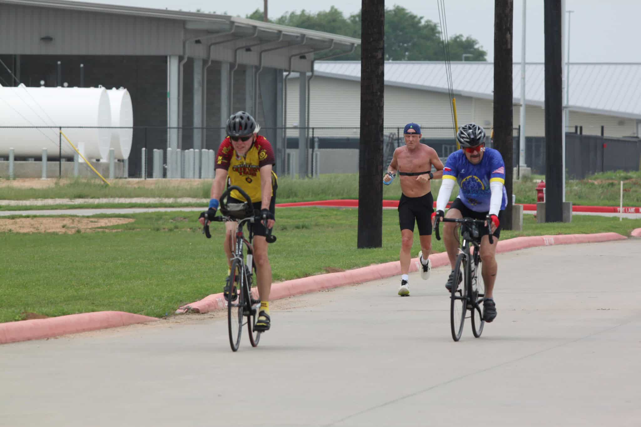 Fast cyclists riding on a street during Bluebonnet Express event.