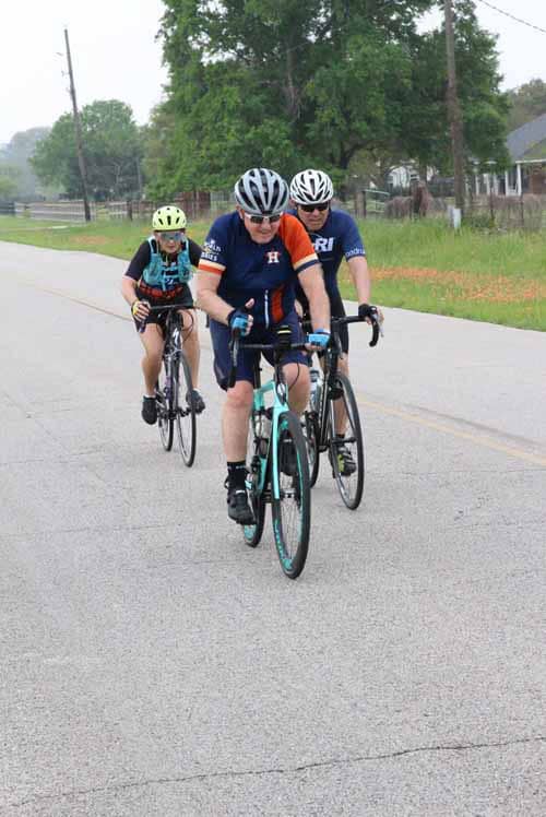 Cyclists riding together on a rural road during daytime, enjoying a scenic bike ride.