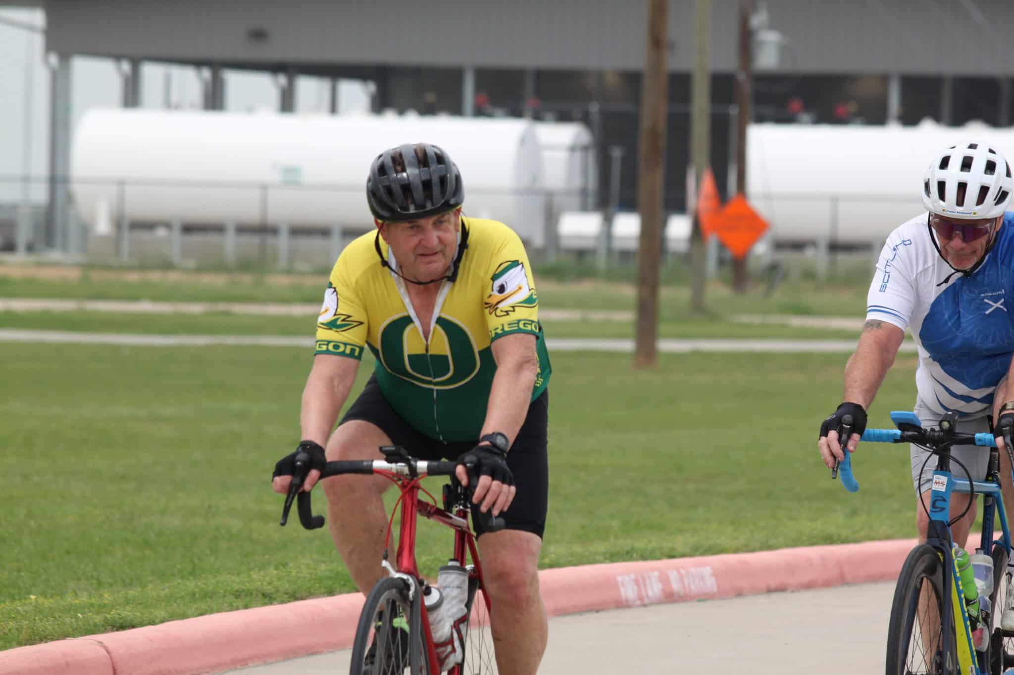 1. elderly man riding a cycling tour bicycle with Oregon Ducks jersey during Bluebonnet Express event.