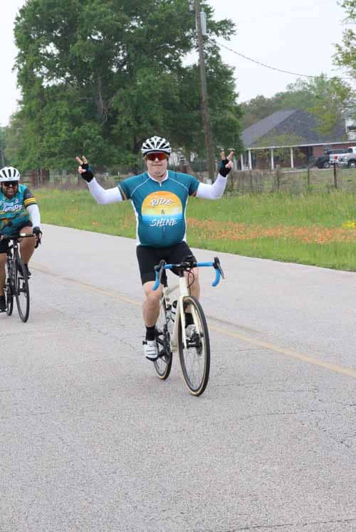 Bright cyclist celebrating on the Bluebonnet Express route, promoting biking fun and fitness.