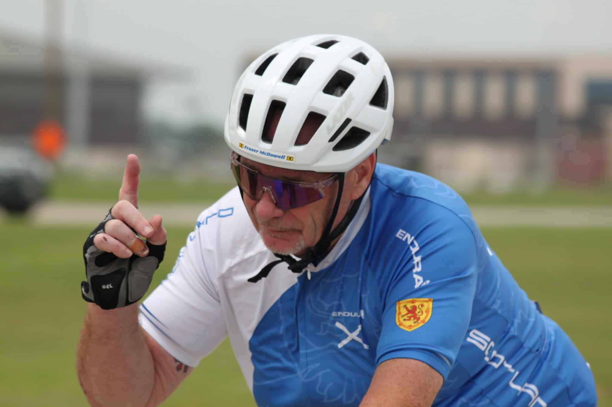 Full-suspension mountain bike rider in blue gear and helmet, ready for adventure.