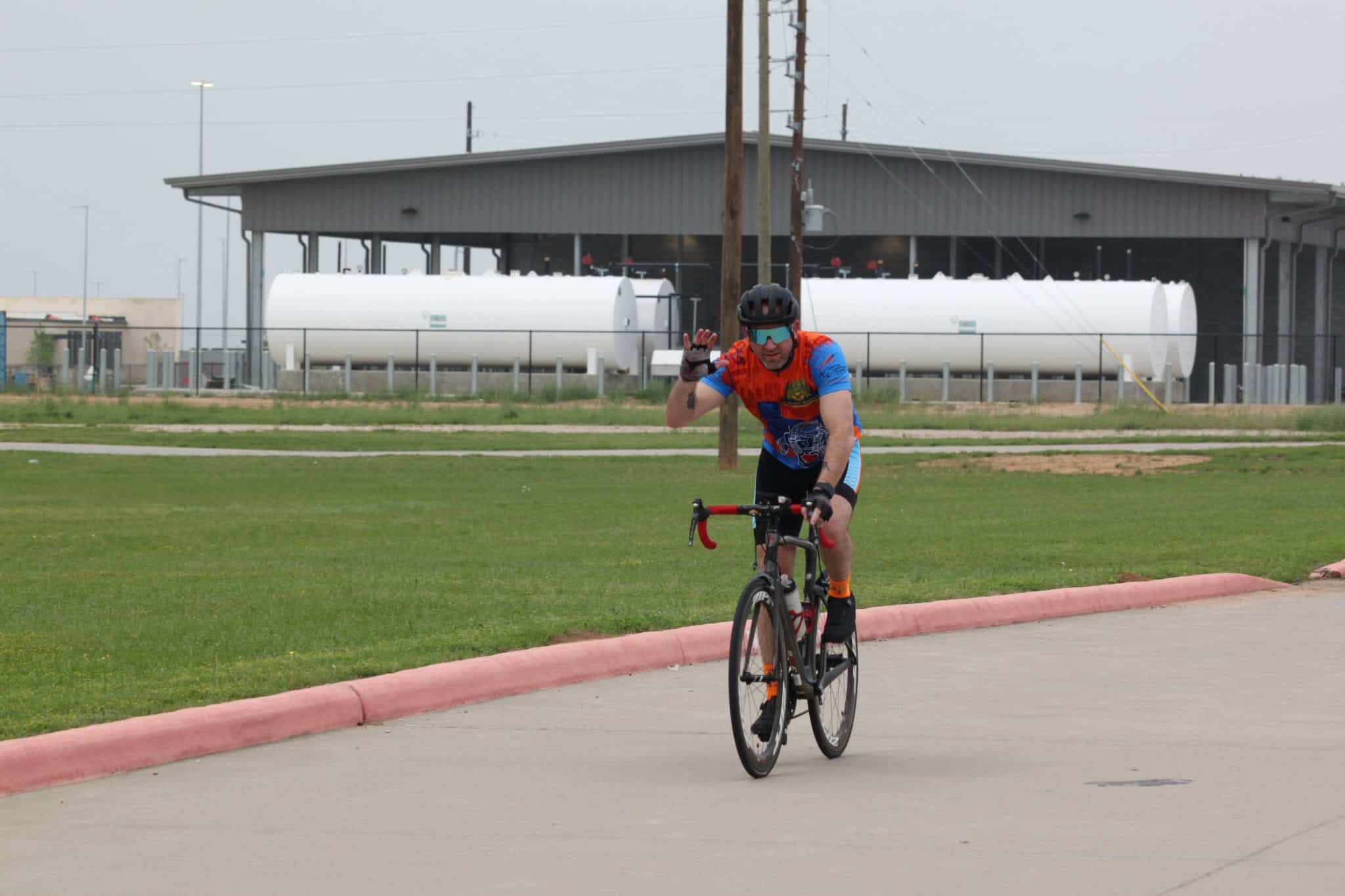 Brightly dressed cyclist riding on the street, promoting Bluebonnet Express bike service.