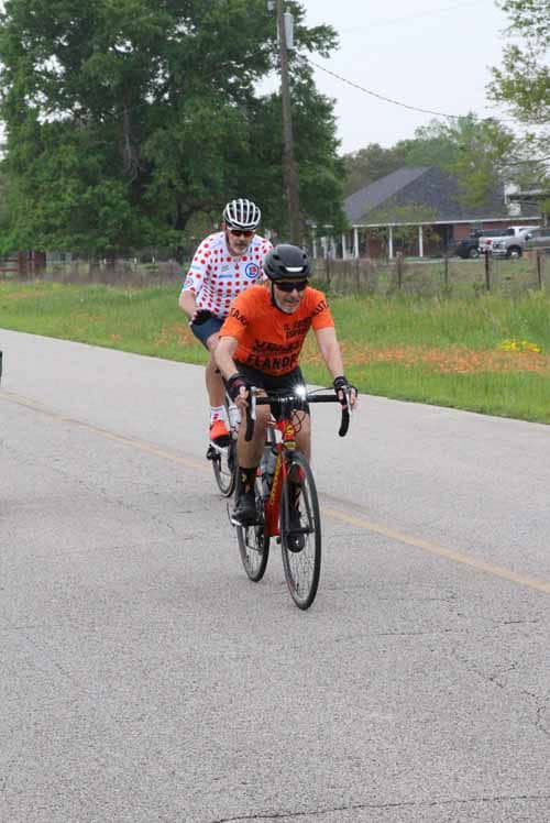 Bright orange and polka dot cycling jerseys at Bluebonnet Express bike event, promoting outdoor fitness and community fun.
