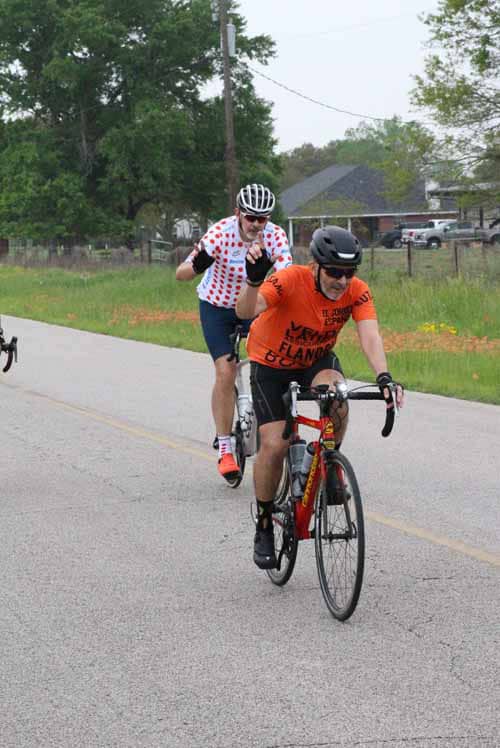 Bright cyclists enjoying Bluebonnet Express ride on rural road in Texas, showcasing scenic cycling adventure.