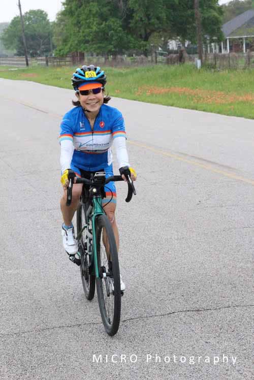 Bright girl riding a road bike during Bluebonnet Express cycling event in Texas under clear skies.