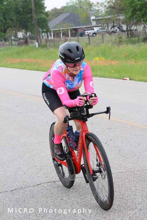 High-performance cycling at Bluebonnet Express with a female cyclist in colorful gear.
