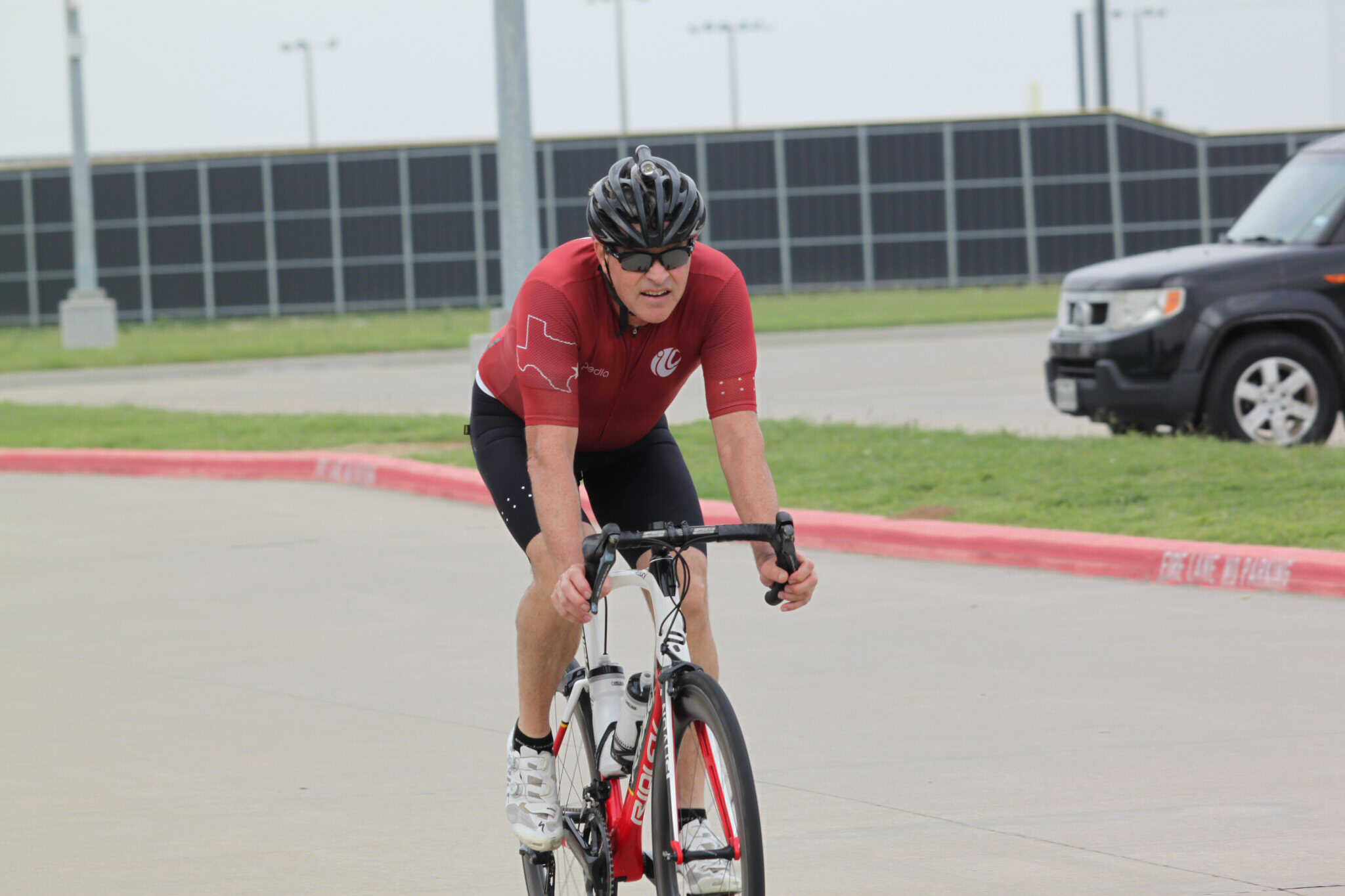 Energetic cyclist riding on a race track during Bluebonnet Express event.