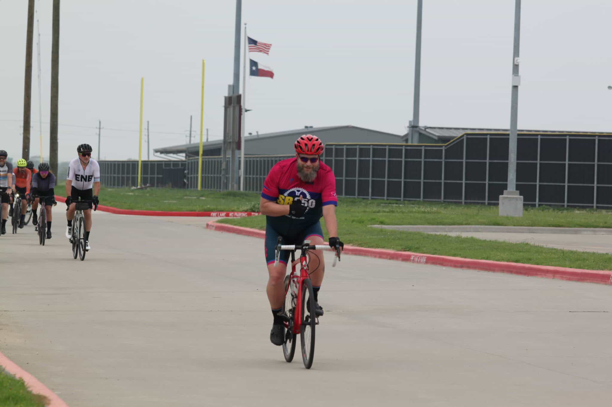 Cyclist riding in a race with other bikers along a road, part of the Bluebonnet Express event.