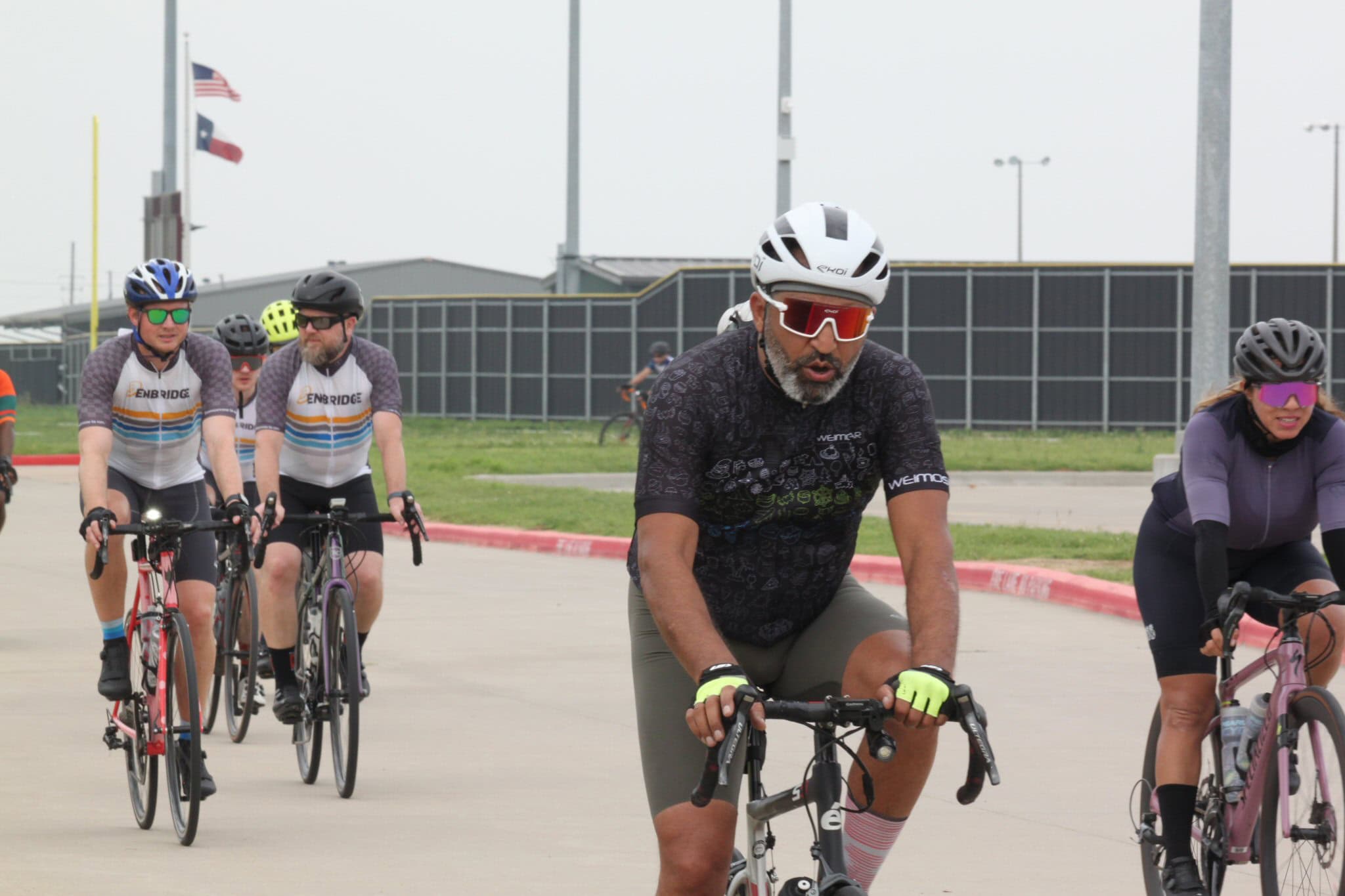 Bright, diverse group of cyclists riding bikes outdoors at Bluebonnet Express event for cycling enthusiasts.