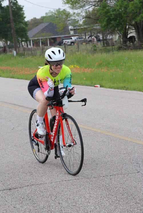 Bright cyclist in colorful jersey riding a road bike during Bluebonnet Express event.