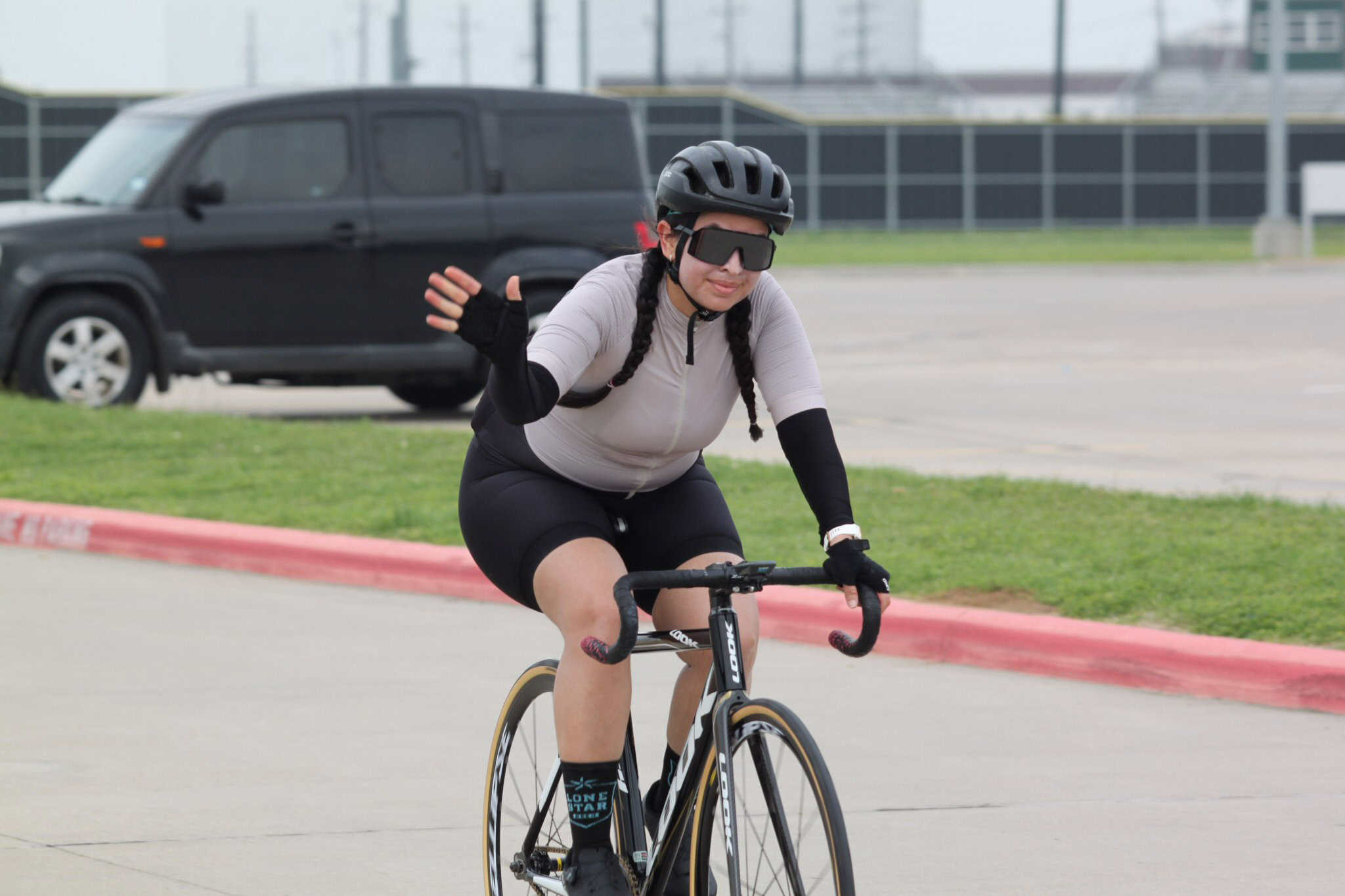 Helmeted female cyclist riding on city street, promoting Bluebonnet Express biking services.