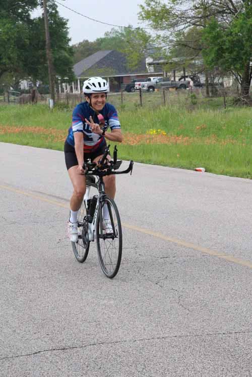 Happy cyclist riding on the street with a smile, wearing a helmet, promoting bike fun and safety.