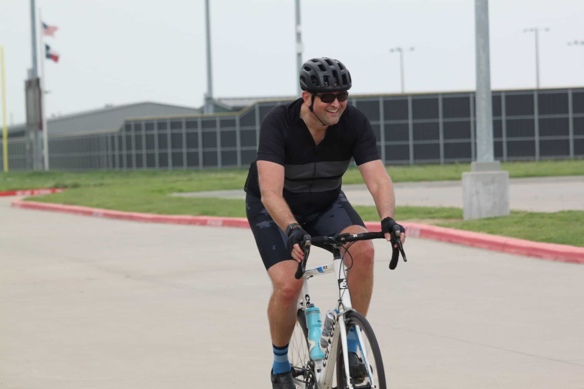 Bright man cycling outdoors on Bluebonnet Express bike trail, enjoying a sunny day ride.