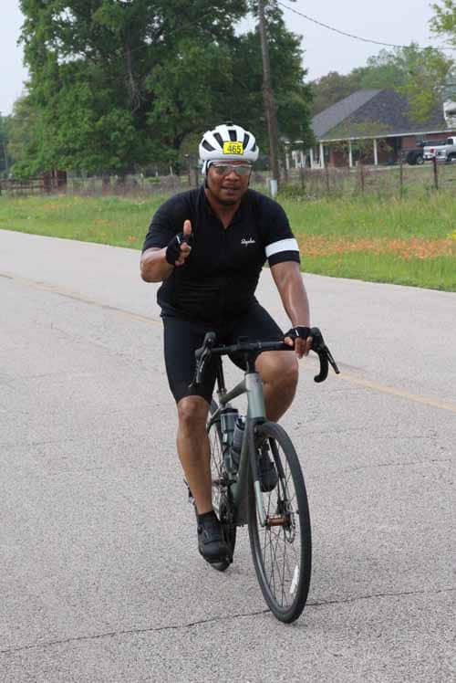 Cyclist riding on the road with helmet and bike, promoting outdoor fitness and cycling safety.