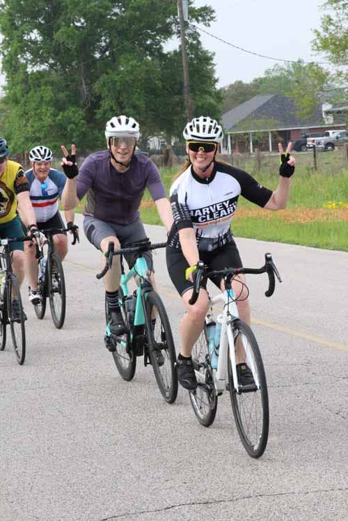 Enjoying a group bike ride with smiling cyclists on scenic Bluebonnet Express route.