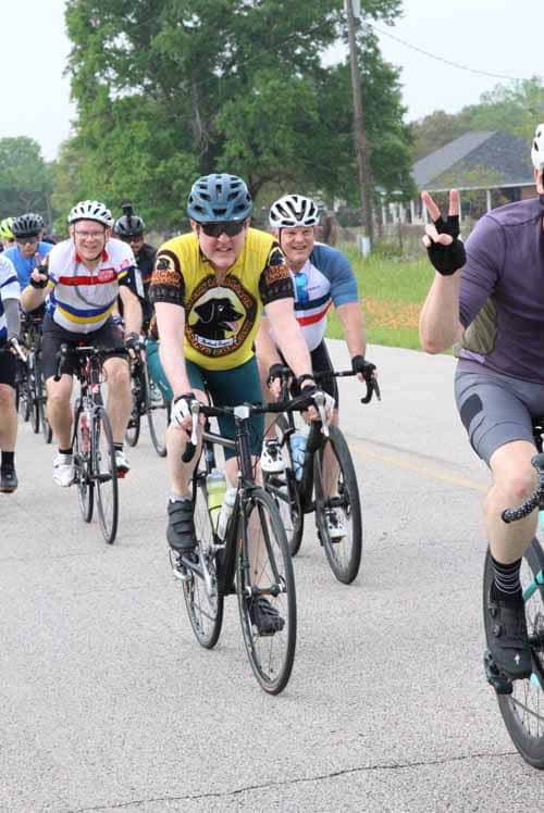 Bright group of cyclists celebrating during the Bluebonnet Express ride, showcasing outdoor biking and community event.