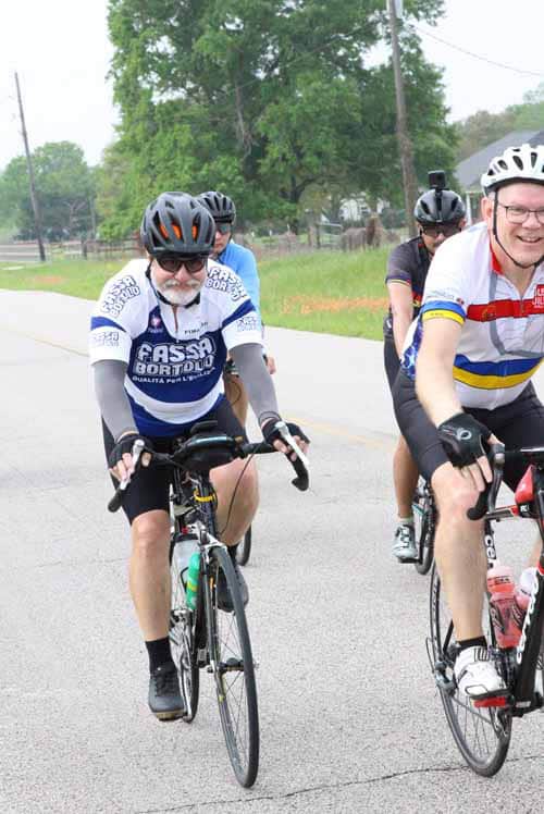 Riders enjoying a scenic bike ride in Bluebonnet County on a bright, sunny day.