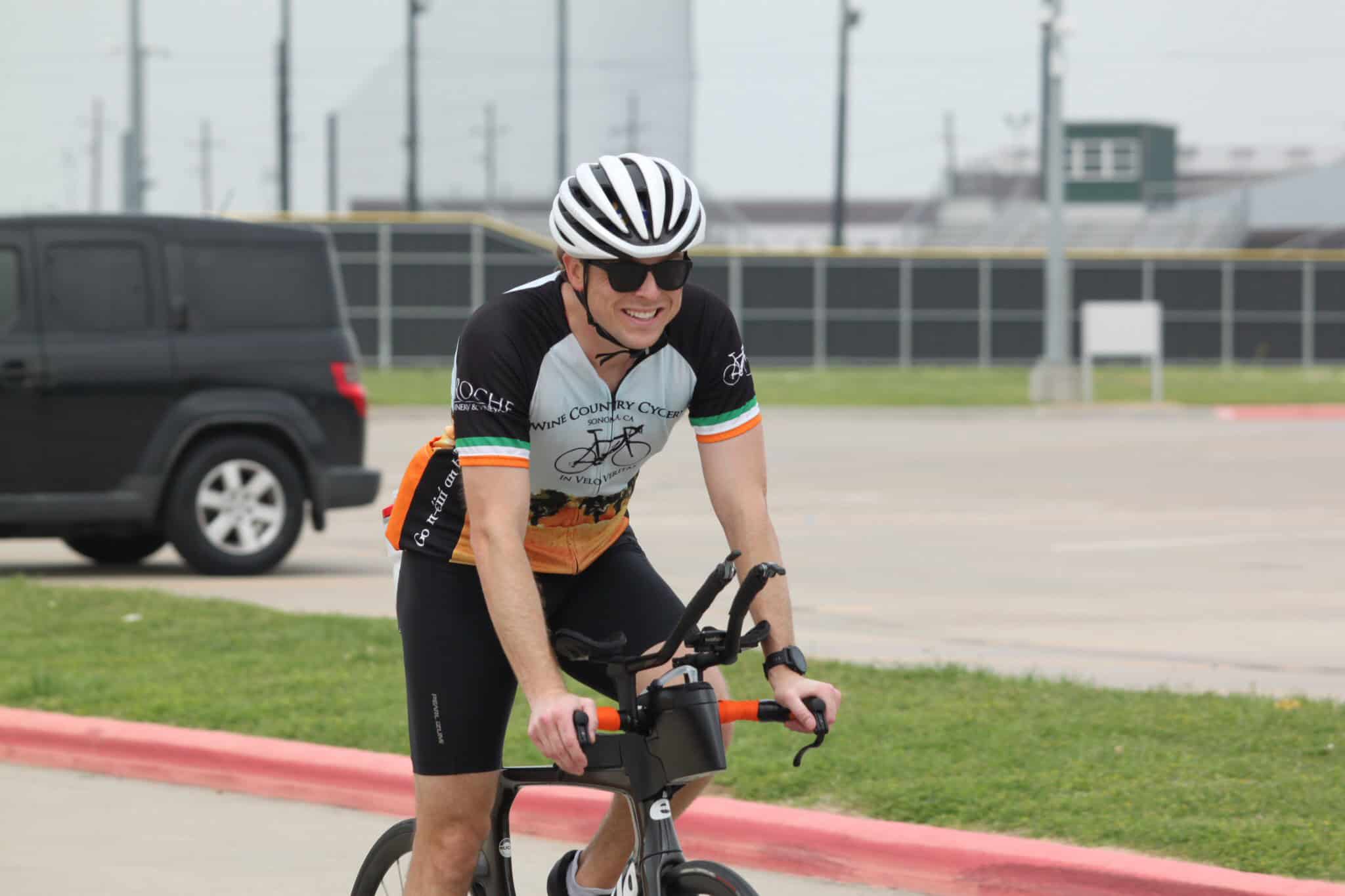 Smiling cyclist riding an e-bike on the road during daytime.