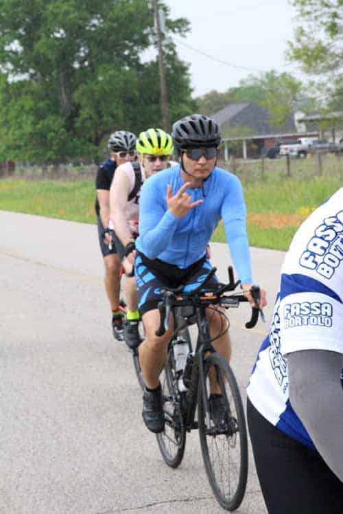 Cyclist making hand gesture during Bluebonnet Express bike ride event.
