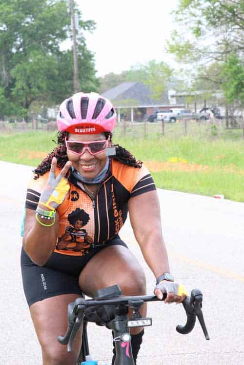 Bright smiling woman cyclist wearing helmet and sunglasses, enjoying a ride outdoors, healthy lifestyle, female biking enthusiast for SEO.