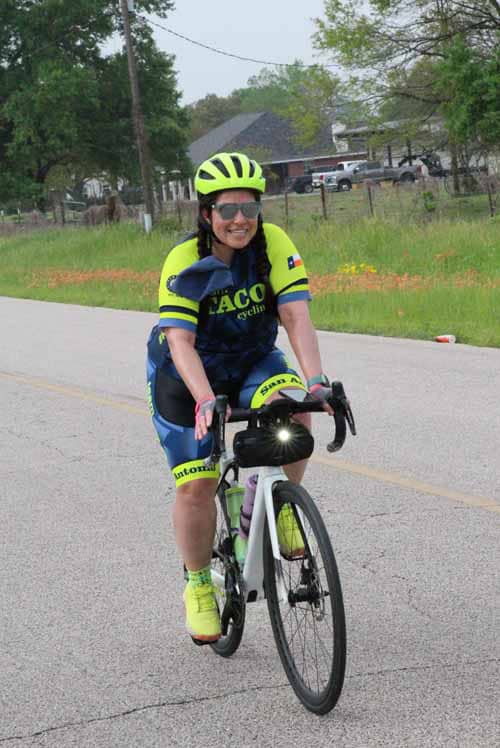 Bright yellow and blue cycling jersey with a smiling woman riding a bike on a rural road.