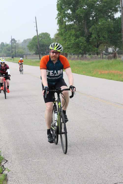 Bicycle rider participating in Bluebonnet Express event on scenic rural road.